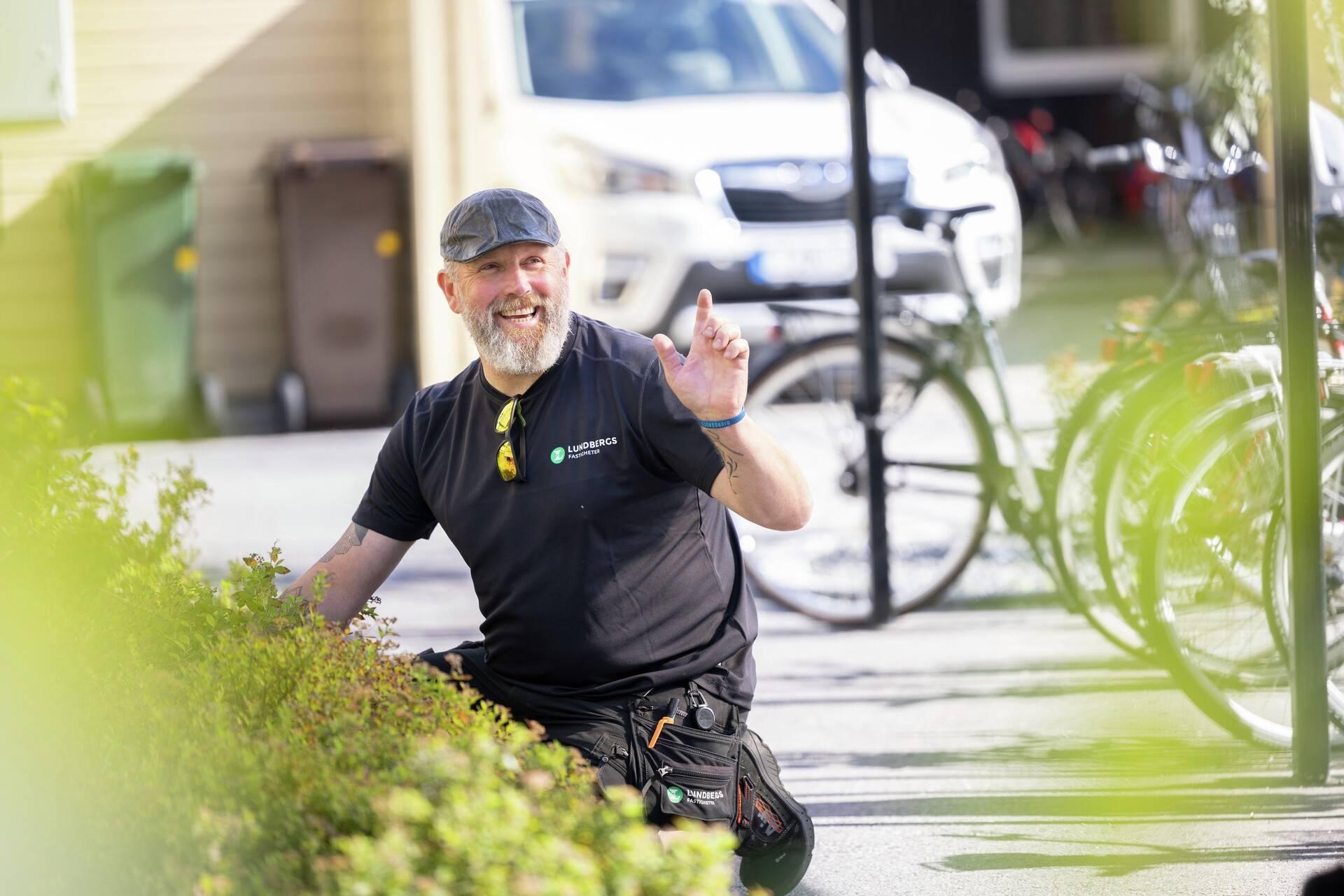 Fastighetsskötare som vinkar till en person.